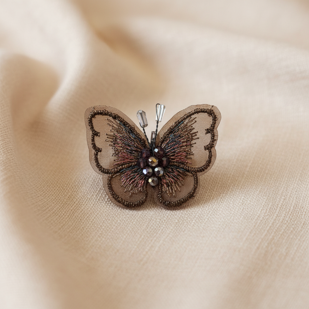Broche borboleta bordado bronze sobre tecido elegante