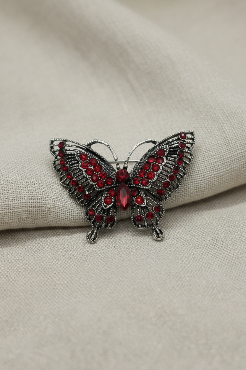 Broche de borboleta prateado sobre tecido natural