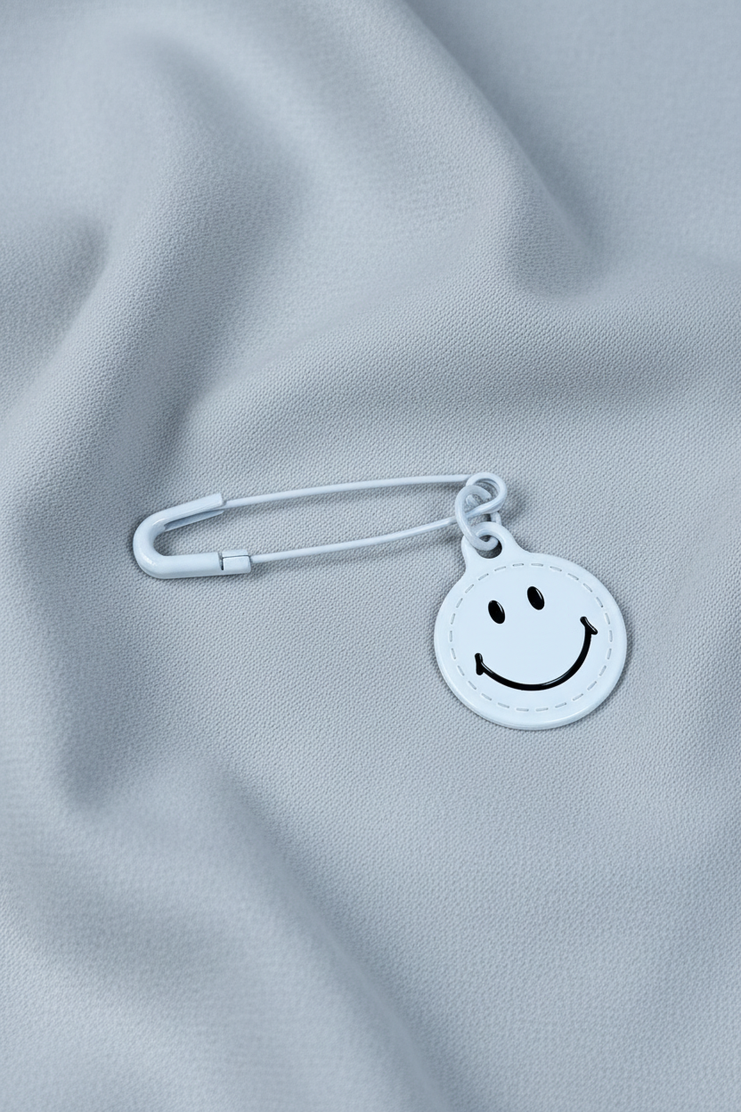 Broche smiley branco sobre tecido fluido