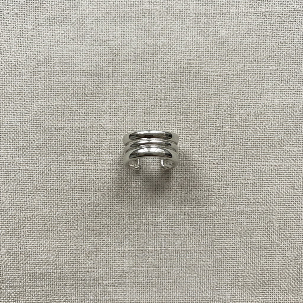 Ear cuff prata sobre tecido de linho