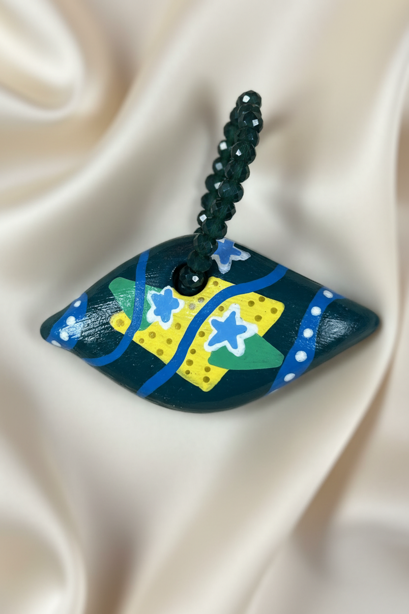 Pingente losango com bandeira do Brasil em close sobre tecido fluido